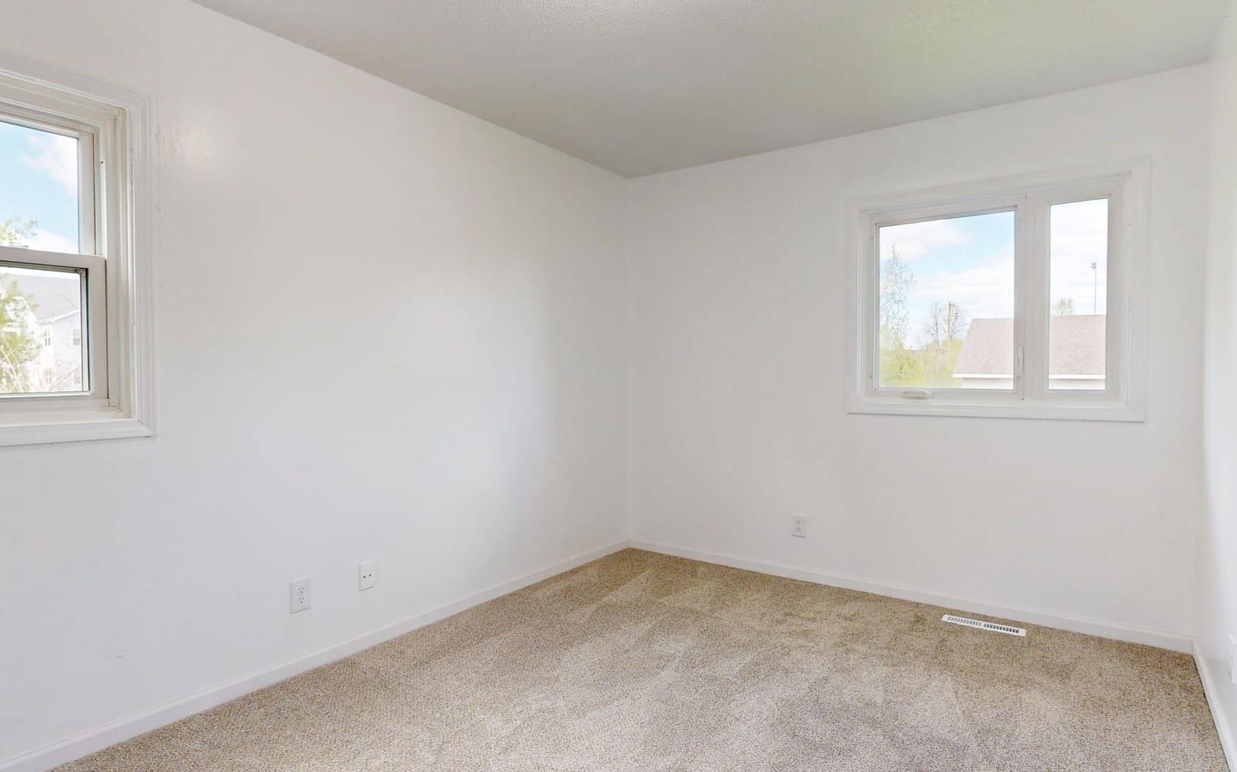 Empty carpeted room with patched white walls waiting on an inspection