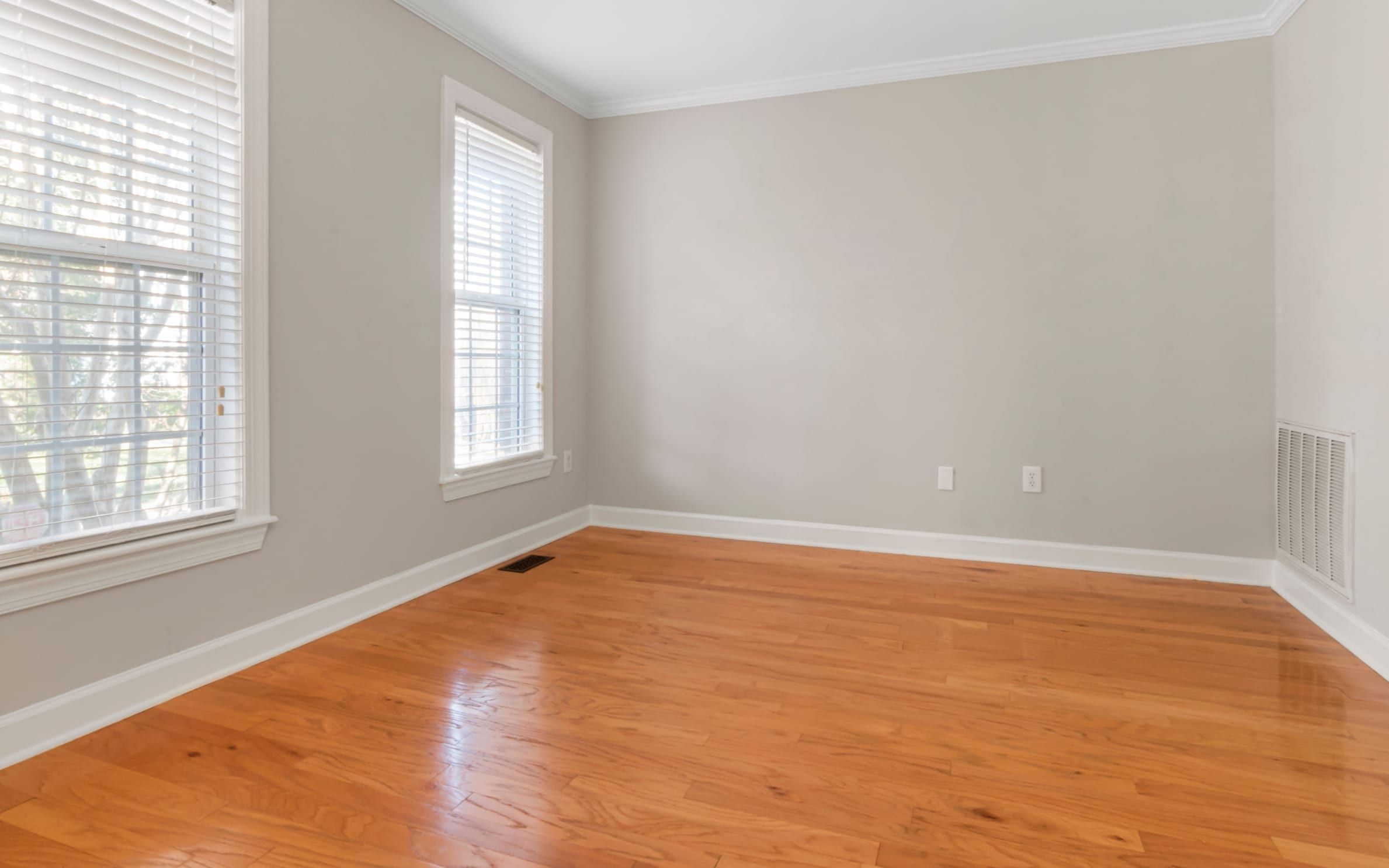 Empty freshly painted room with hardwood floors, ready for a final walkthrough