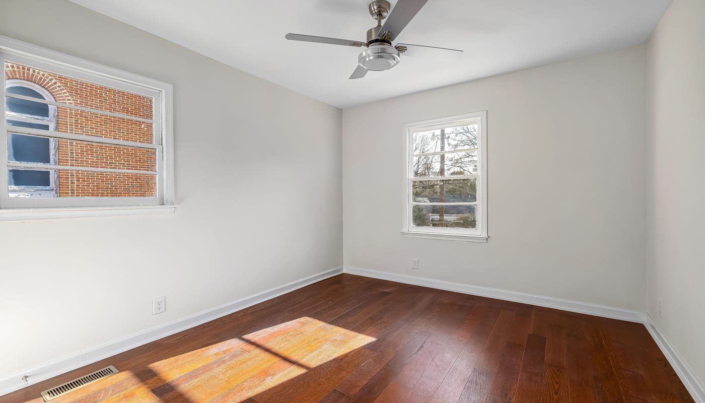 Empty room with wood floors and white trim prepped for interior painting