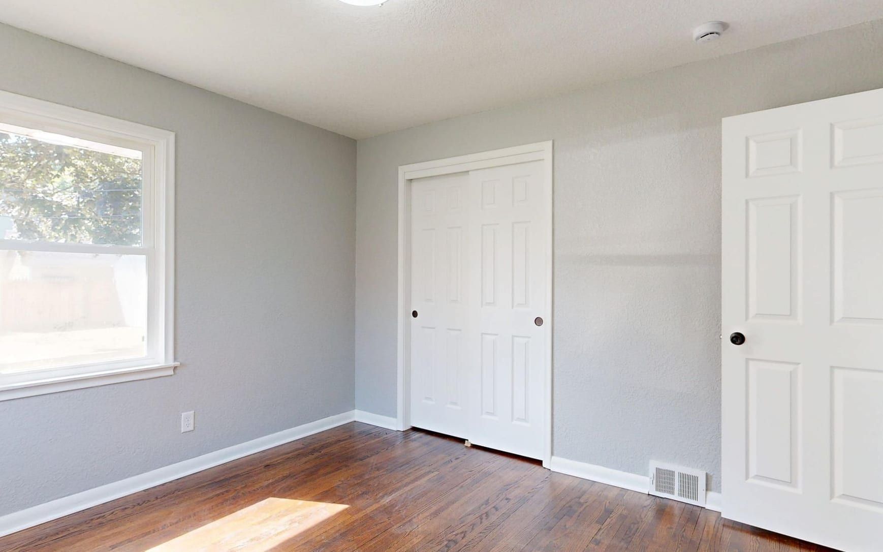 Repainted bedroom with closet doors and trim finished in white