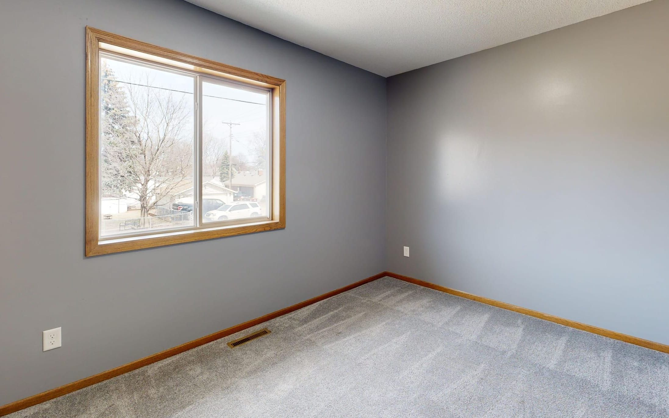 Room repainted in soft grey with clean cut lines along the window trim