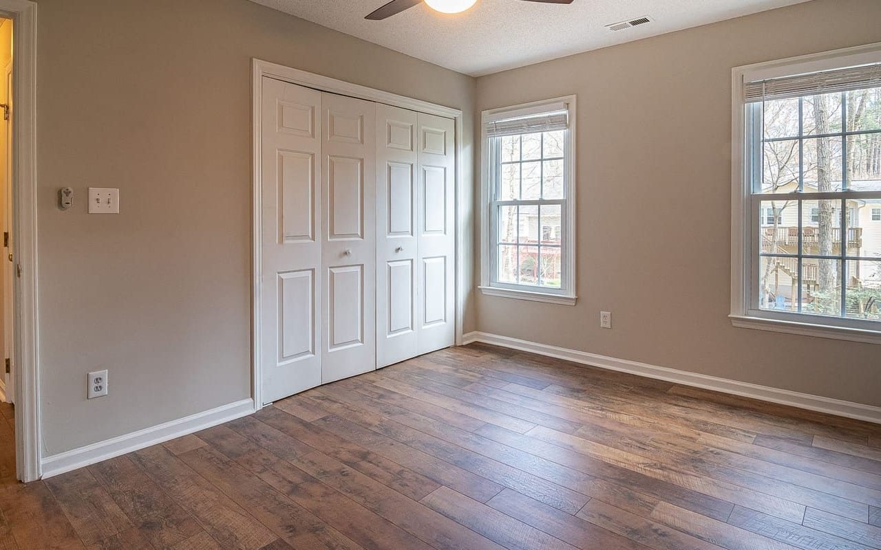 White six-panel closet doors, casings, and baseboards in a freshly painted room