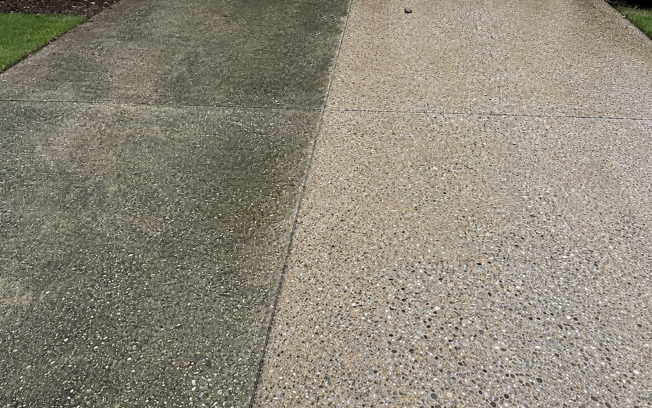 Concrete drive with a washed strip running up the middle of the dirty surface