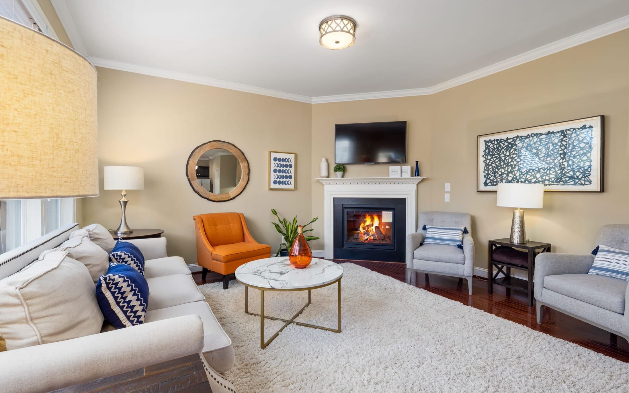 Sitting room with a TV mounted on the wall beside the corner fireplace