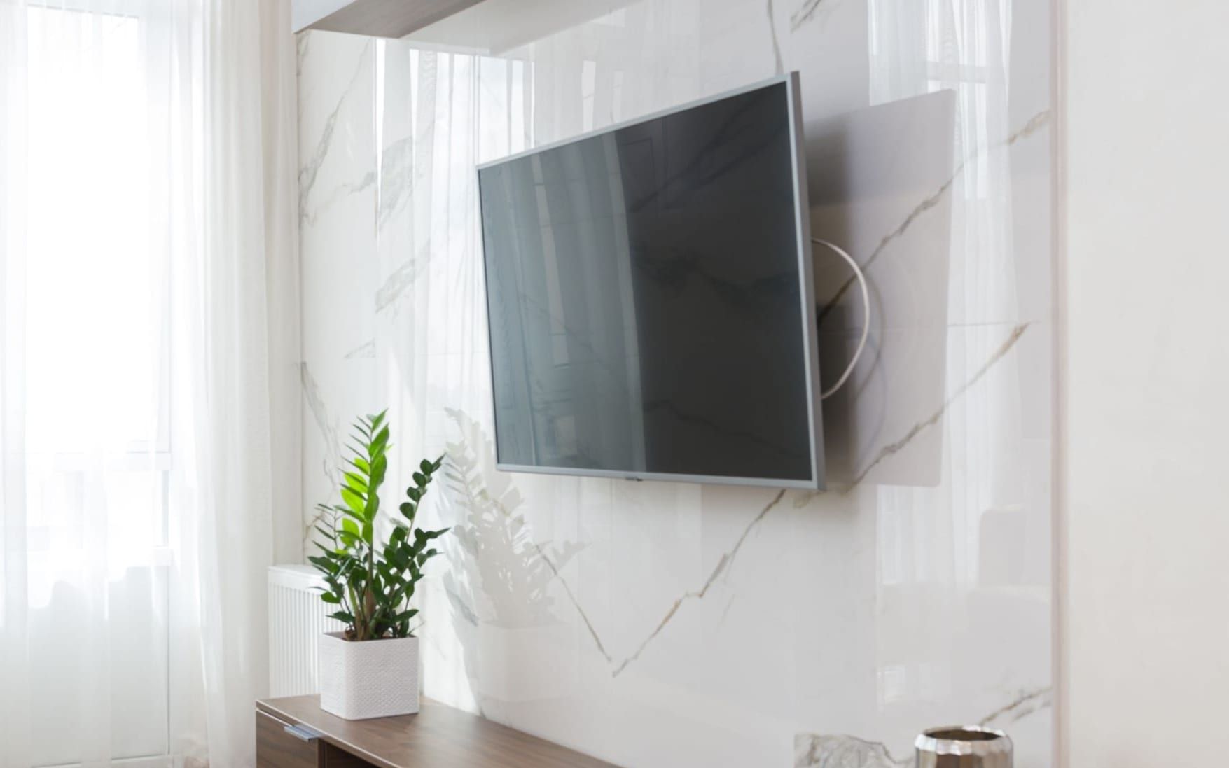 Television mounted on a marble feature wall with every cable concealed